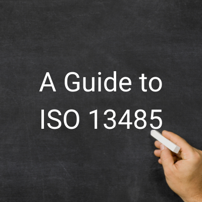 Image shows a person writing on a chalk board in white chalk with the words " A Guide to ISO 13485" - Patient Guard uses this image to describe medical device and IVD regulatory and quality assurance related content.