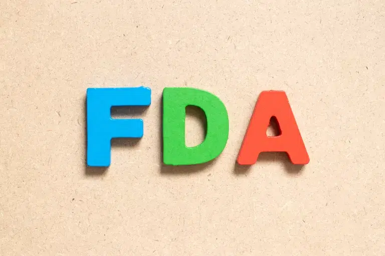 Color alphabet letter in word FDA (abbreviation of food and drug administration) on wood background - This image is used by Patient Guard to represent their USA FDA Medical Device Consultancy services